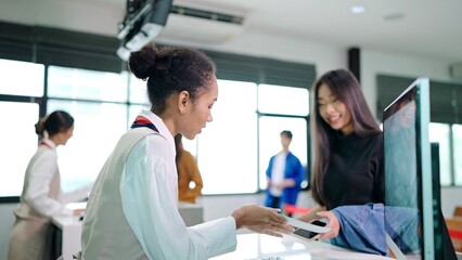 Asian passengers traveler giving boarding pass and passport to customer check in officer at service counter airport