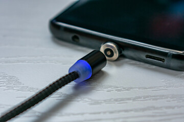 Magnetic cable for charging smartphone, close up.