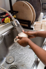 Woman washing a cup in the sink