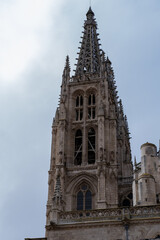 Fototapeta na wymiar El campanario de la Catedral de Burgos bajo el cielo soleado vista desde abajo viendo los detalles de las vidrieras.