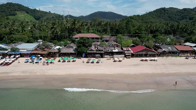 Slide drone footage of Lanta Klong Nin beach on sunny day. Ko Lanta, Krabi Province, Thailand.
