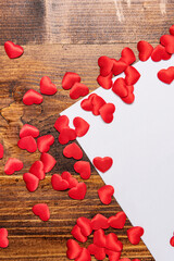 red cloth hearts with blank sheet on wood background