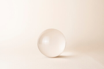 glass sphere on beige background - obrazy, fototapety, plakaty