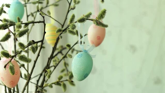 Holidays and object concept - close up of pussy willow branches decorated by easter eggs. Banner, copyspace.