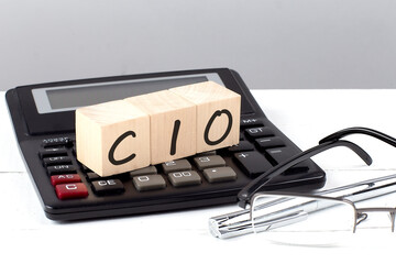 CIO concept on wooden cubes on calculator on white background