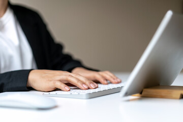 Female business person using wireless keyboard and digital tablet.