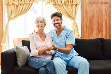 Smiling caregiver holding senior woman's hand
