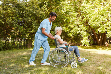 Nurse pushes elderly woman in a wheelchair