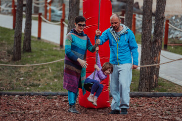 Obraz premium Family fun in the park. Happy family spending time in park and playing with their daughter