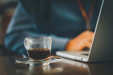 Close-up of a businessman sitting at a desk working on her laptop