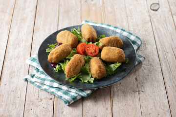 Traditional spanish fried croquettes on wooden table