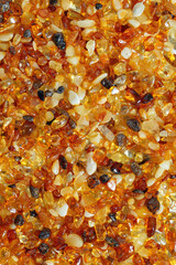 Natural gemstone amber texture background, small stones yellow orange gradient color. Natural mineral material for jewelry. Top view Amber texture. Aesthetic sunstones wallpaper, pieces ancient resin.