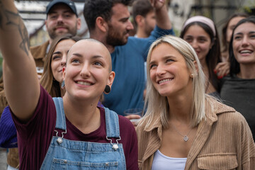 Young friends taking a selfie at a concert or party - Diverse group of friends capturing a moment outdoors