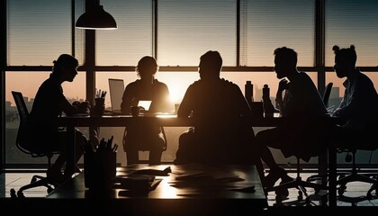 A group of people sitting around a table in a room with windows and a sunset backlighting a stock photo les automatistes