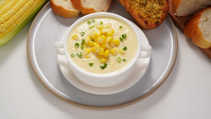 Corn Soup and Bread breakfast menu on white table