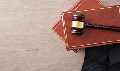 Gavel on lawbooks and toga on wooden table