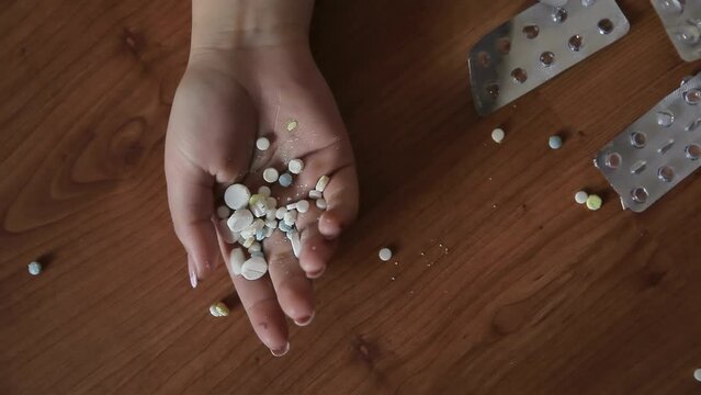 The woman committed suicide by taking an overdose of drugs. Pill poisoning. Poison pills in the hand of a woman who committed suicide due to a drug overdose. Concept of depression or suicide despair