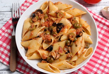 Tasty dish of Italian pasta topped with tuna sauce, black olives, green olives, capers, basil and chilli pepper. These are gypsy pens.