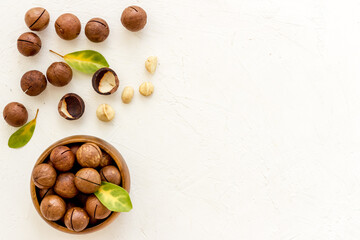 Flat lay of macadamia nuts in bowl, top view. Healthy food background