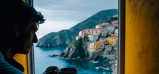 Man traveler drinking morning coffee overlooking the city view of overlooking Manarola town, Cinque Terre, Liguria, Italy. Travel concept and morning with breakfast at the hotel. Generative AI