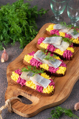 Homemade sandwiches with salted herring, beetroot and egg on wooden board, Vertical format