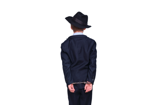 A boy in a hat stands with his back with handcuffs on his hands, isolated on a white background