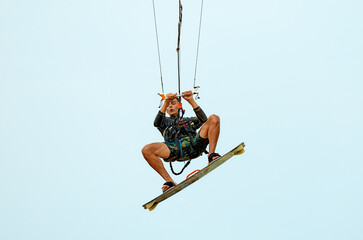 Young kitesurfer jumping in the sky on the board