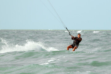 Kite surfing, kite surfing man preparing to make a jump, cutting ocean waves, kite surfing on...