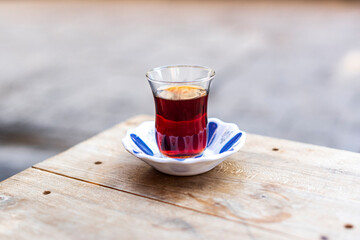 Delicious cup of black tea on wooden table, close up