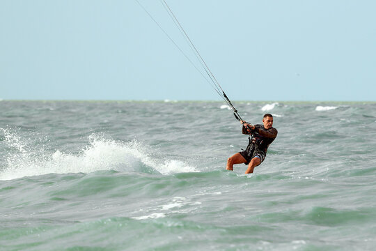 Kite surfing, kite surfing man preparing to make a jump, cutting ocean waves, kite surfing on vacation