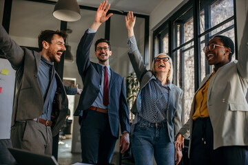 Happy united diverse colleagues team people together.  Business teamwork results are motivated by business success victory loyalty unity concept, good corporate relations, and team building.
