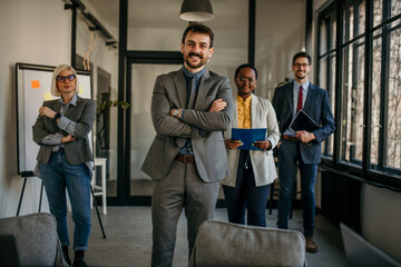 Portrait of handsome smiling businessman with his colleagues. Multi-ethnic group of business...