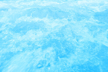 Defocus blurred transparent blue colored clear calm water surface texture with splashes and bubbles. Trendy abstract nature background. Water waves in sunlight with copy space. Blue watercolor shining