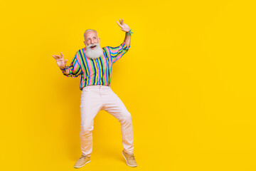 Fototapeta na wymiar Full length photo of cheerful charming man wear colorful shirt daning looking empty space isolated yellow color background