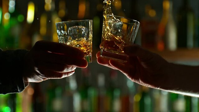 Super Slow Motion Shot of Clinking Two Glasses of Whiskey. Filmed on high speed cinematic camera at 1000fps