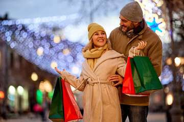 Happy loving mid adult couple enjoy shopping together in the city