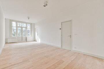 an empty room with white walls and wood flooring in the center of the room, there is a door that...
