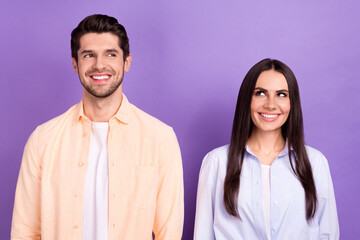 Fototapeta na wymiar Photo of two funny cheerful partners beaming smile look empty space brainstorming isolated on violet color background