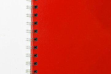 Close-up of a red notebook with checkered pages. Spiral notebook isolated