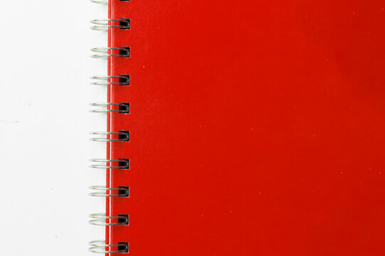 Close-up of a red notebook with checkered pages. Spiral notebook isolated