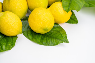Ripe yellow juicy lemons with leaves isolated on white background