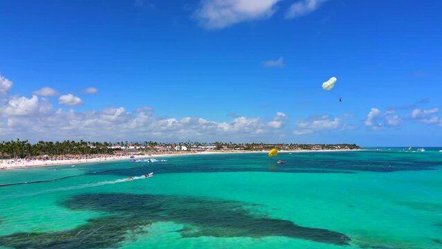 Aerial view of turquoise caribbean sea coast with all Inclusive hotels. Tourists having fun and enjoy beach activities Parasailing and Banana Boat Ride