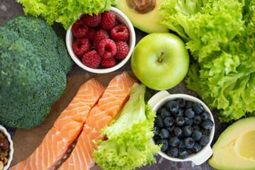 Ketogenic diet concept. A set of products of the low carb keto diet. Green vegetables, nuts, fish salmon, vegetables, nuts, berries. Healthy food concept.