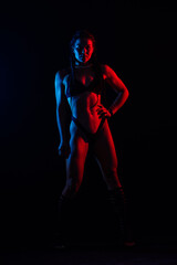 Beautiful female body on dark background in red blue neon light. Fit and sportive, sensual.