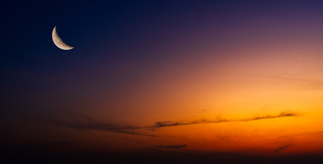 Dusk sky twilight in the evening with sunset orange sunlight and crescent moon free space for religion Islamic text Ramadan, Eid Al Adha, Eid Al Fitr, Eid Mubarak