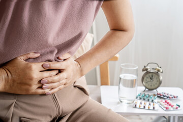 irritable bowel syndrome IBS concept with woman hand holding a stomachache having problems with the digestive system like diarrhea and constipation - obrazy, fototapety, plakaty