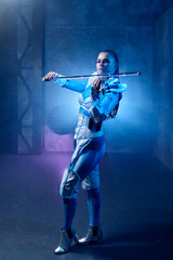 Woman violinist playing electric futuristic violin with selective focus