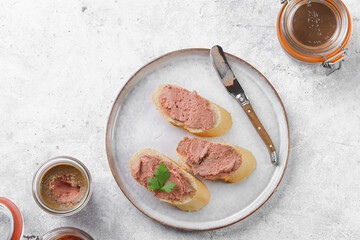 Homemade chicken liver pate on fresh french white wheat baguette slices on wooden plate, glass...