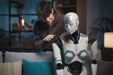 Smart teenager fixing an AI robot at home