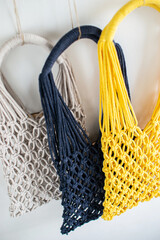 Handmade macrame shopping bags on the light background, ECO friendly. Embroidery. Modern summer concept